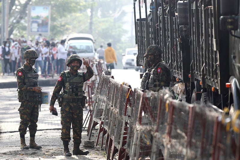 Soldiers stand near barricades outside the Central Bank of Myanmar building in Yangon, Feb. 15, 2021, following the military coup. (AP)