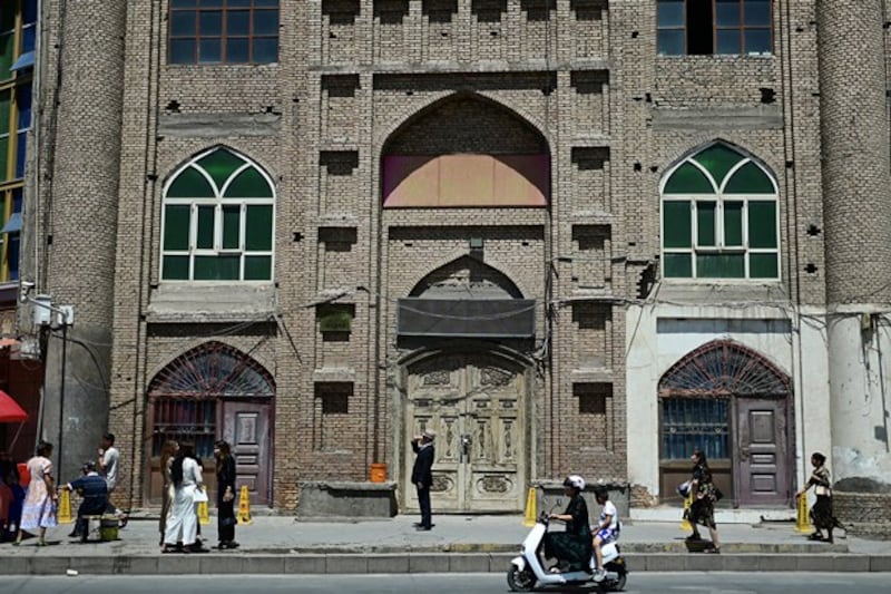 People walk past a disused mosque in Kashgar in northwestern China's Xinjiang region, July 13, 2023. (Pedro Pardo/AFP)