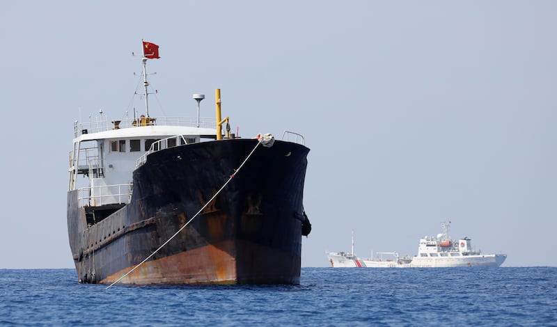 A Chinese flag flutters on a fishing boat while a China Coast Guard patrols at the disputed Scarborough Shoal, April 5, 2017.