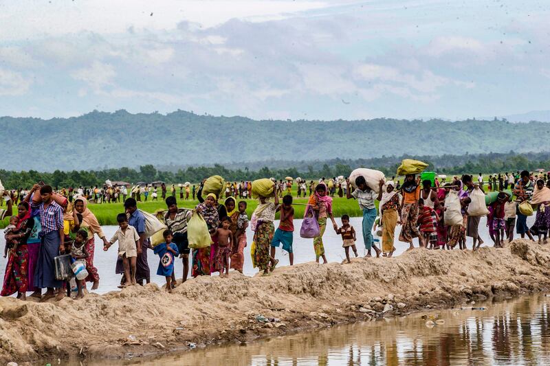 In this Oct. 19, 2017 file photo, Rohingya Muslims, who spent four days in the open after crossing over from Myanmar into Bangladesh, carry their belongings after they were allowed to proceed towards a refugee camp, at Palong Khali, Bangladesh. Credit: AP Photo