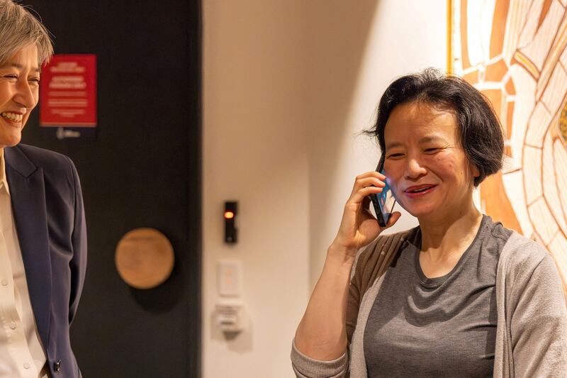 Australian journalist Cheng Lei speaks on the phone on arrival at Melbourne Airport in Melbourne, Australia, on Wednesday, Oct. 11, 2023. Credit: AAP Image/Supplied by the Department of Foreign Affairs and Trade via Reuters