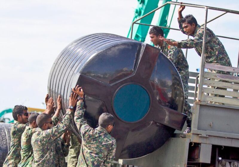 Maldivian security personnel load a water tank onto a military vehicle to fill it with treated water in Malé, capital of the Maldives, Dec. 5, 2014. The capital is located on a low-lying island in the Indian Ocean that has no natural water source and depends entirely on treated seawater. (Sinan Hussain/AP)