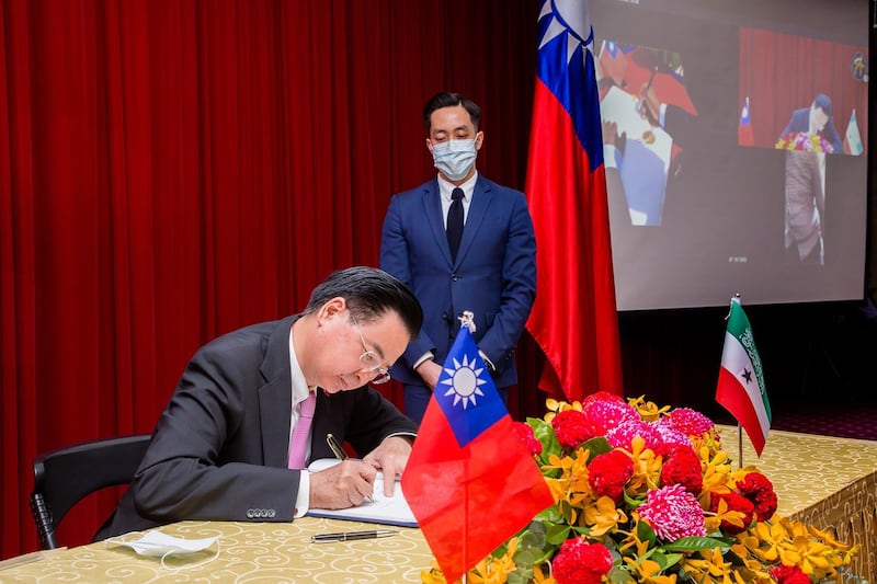 台湾外交部长吴钊燮在台北与索马里兰视讯连线致词，并与索国代表穆雅辛同步异地签署合作协定。（外交部提供）