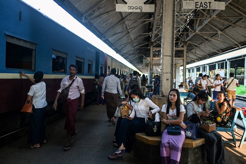 Commuters walk on a platform at Yangon Railway Station in Yangon on March 18, 2020. (Ye Aung Thu/AFP)