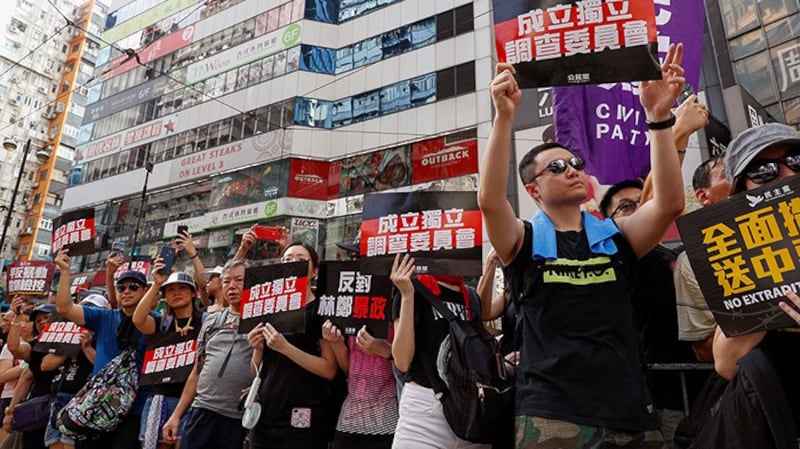 2019年7月21日，香港反送中大游行时，示威者举着标语“成立独立调查委员会”。（美联社）