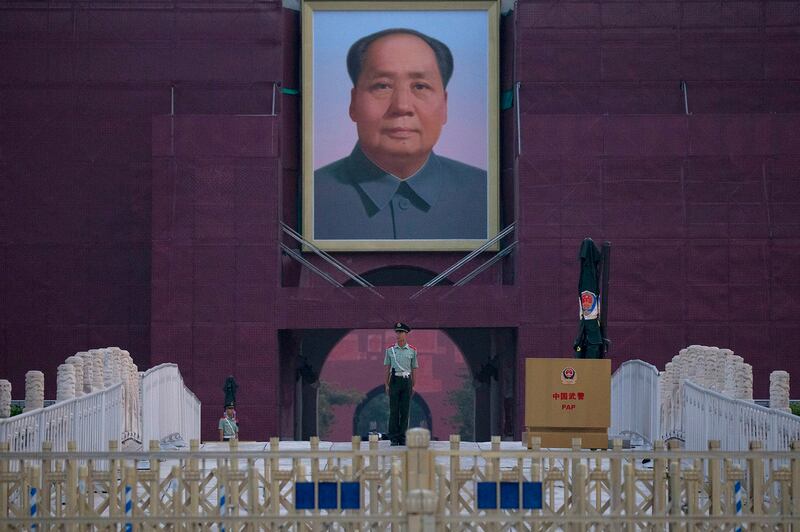 A Chinese paramilitary policeman stands guard in front of Mao Zedong's portrait on Tiananmen Gate, Credit: Ng Han Guan/AP