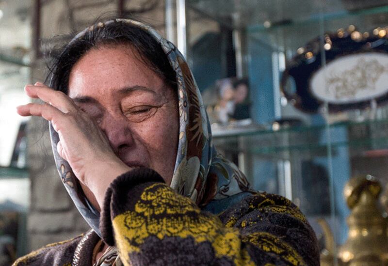 Nasiphan Qunahun, mother of Ilham Tohti, cries at her son's house a day after his arrest in Beijing, Jan. 16, 2014. (Andy Wong/AP)