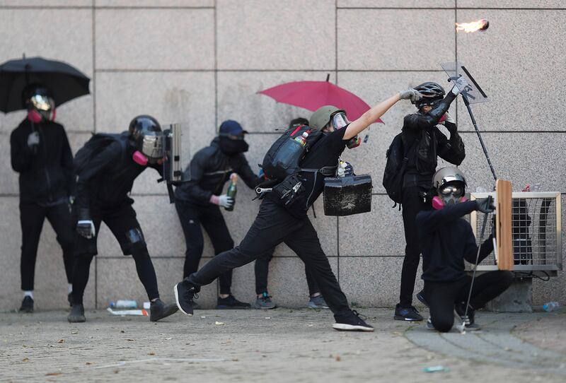 A protester throws a molotov cocktail during clashes with police outside Hong Kong Polytechnic University in Hong Kong, Nov. 17, 2019.