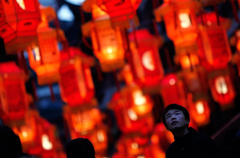 上海市中心豫园，一名男子走过农历新年的红灯笼装饰。（路透社）