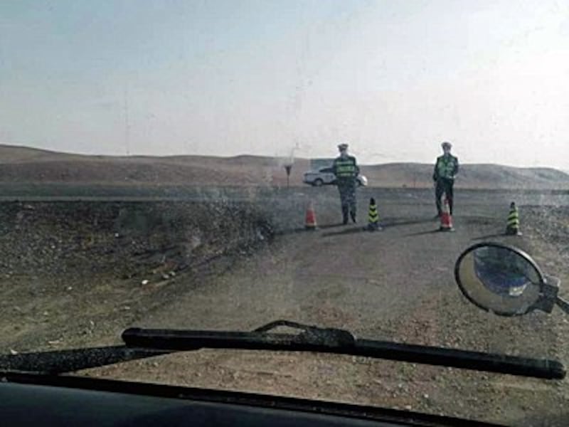 Police stop a vehicle at a roadblock in Inner Mongolia's Zaruud Banner amid pollution protests by local herding communities, April 2016.