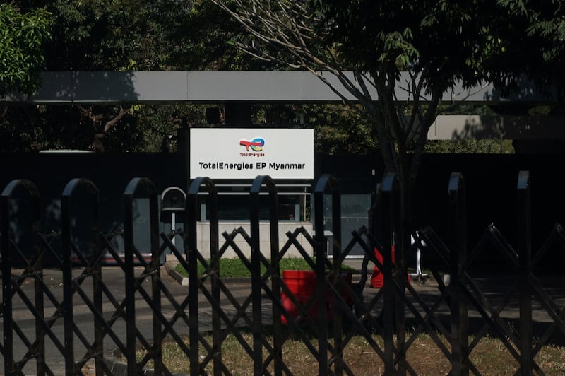 A signboard for TotalEnergies EP Myanmar is seen past a shuttered gate in Yangon, Jan. 22, 2022. AFP