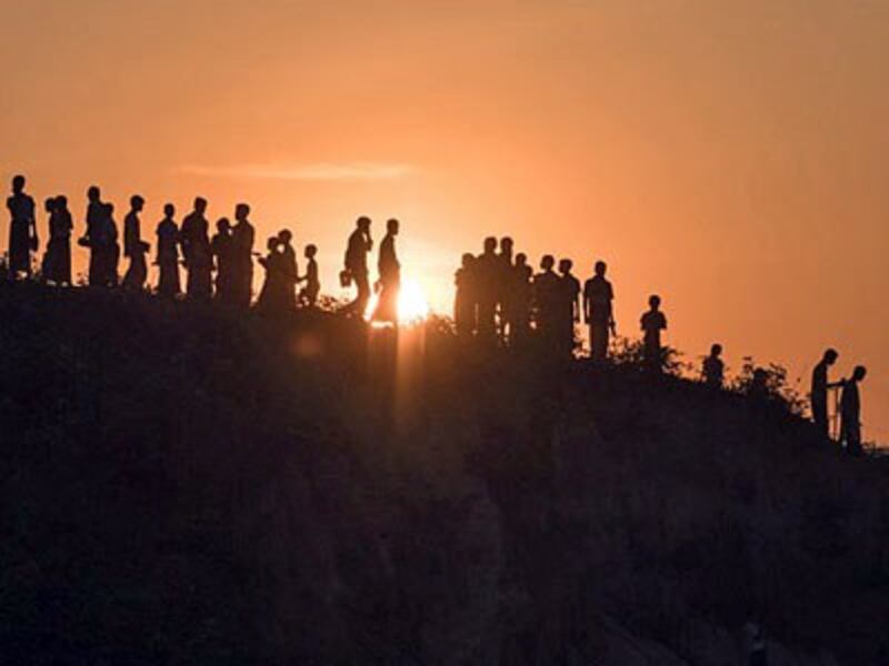 Rohingya Muslim refugees from northern Rakhine state in Myanmar walk down a hillside in the Kutupalong refugee camp in Cox's Bazar in southeastern Bangladesh, Nov. 26, 2017.