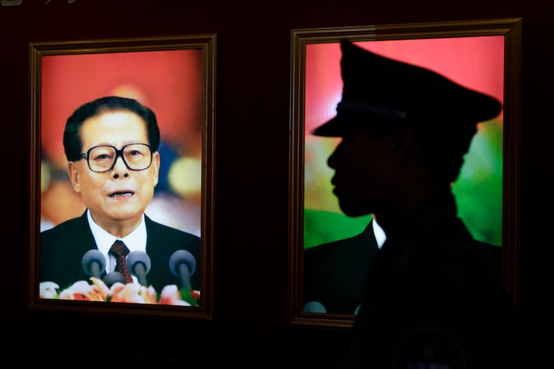 A security guard stands next to a portrait of China's former President Jiang Zemin at an exhibition to celebrate the 90th anniversary of the founding of the Communist Party of China (CPC) in Beijing July 7, 2011. Credit: Reuters