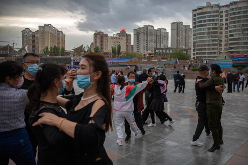 People dance to music at a public square in Aksu in western China's Xinjiang Uyghur Autonomous Region, as seen during a government organized trip for foreign journalists, April 20, 2021. China has focused on promoting its narrative on Xinjiang that includes happy Uyghurs living stable lives. Credit: Mark Schiefelbein/AP