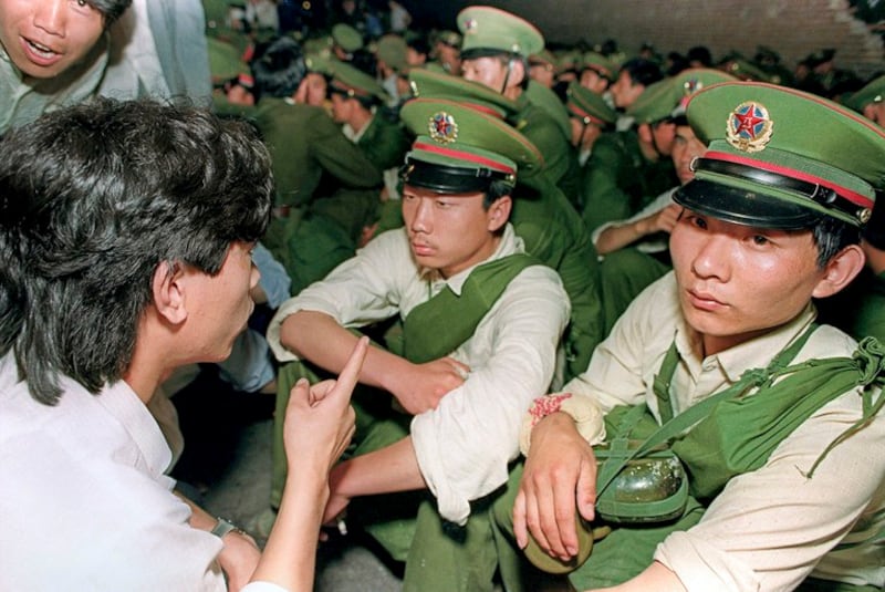 1989年6月3日，在北京市中心，一名学生抗议者要求解放军士兵离开。（亨丽埃特/法新社）