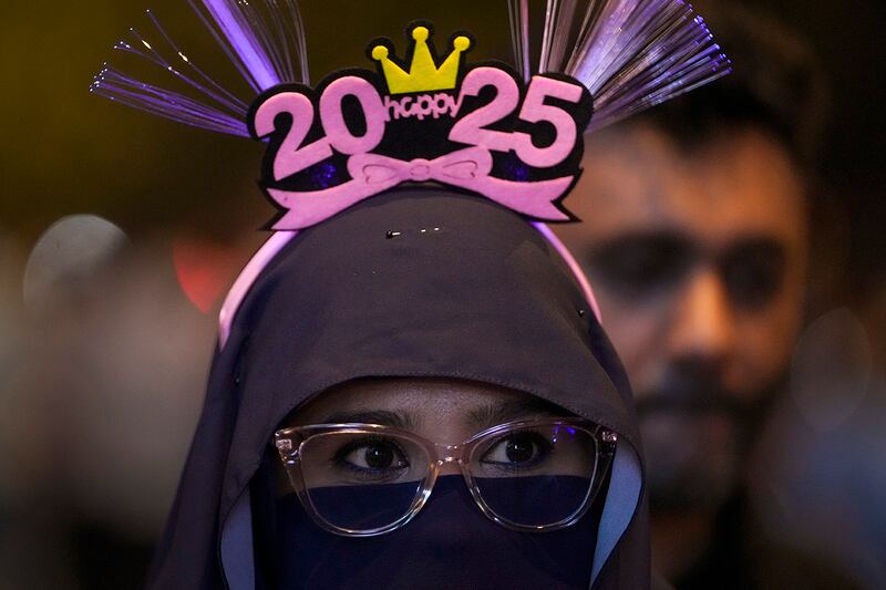 A woman watches the fireworks at the Petronas Towers in Kuala Lumpur, Malaysia, Dec. 31, 2024.