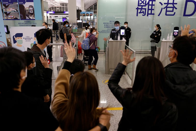 A family emigrating to Scotland waves goodbye to friends at Hong Kong International Airport, Dec. 17, 2020.