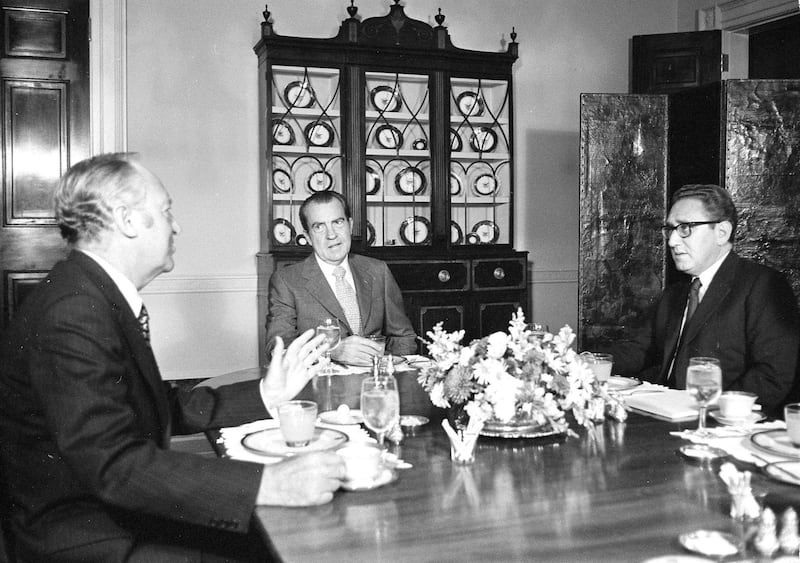 Presidential advisor Henry Kissinger [right] reports to President Richard Nixon [center] on his four days of talks in Paris with North Vietnam's negotiators at breakfast in the family dining room at the White House, Oct. 13, 1972. (John Duricka/AP)