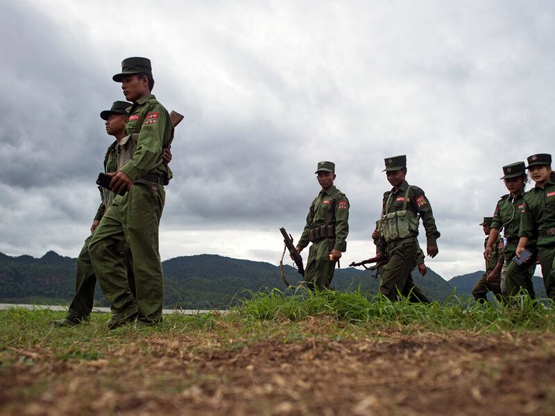 Members of UWSA patrol a field in Poung Par Khem, near the Thai and Myanmar border on June 26, 2017.