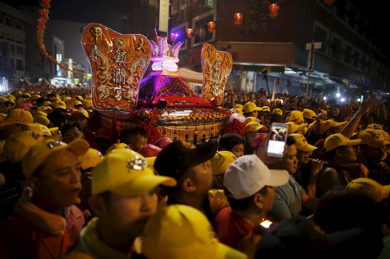 台湾台中，在为期九天的游行中，信徒们聚集在一辆载着道教女神妈祖雕像的战车旁。（路透社）