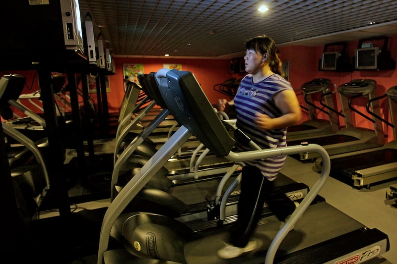 A woman runs on a treadmill as part of her training during a six-week program at a weight loss campus in Beijing , August 26, 2011.