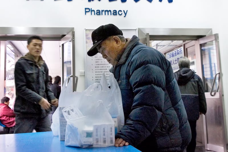 A Chinese patient looks at his medicine, after picking it up at a pharmacy, inside a hospital in Beijing, Jan. 10, 2008.