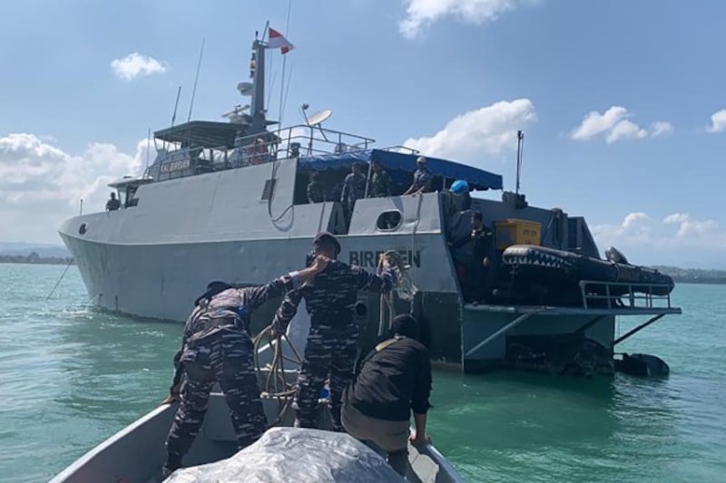 Indonesian sailors deliver supplies to a ship destined for the Rohingya boat stranded in waters off Bireuen, Aceh province, Dec. 29, 2021. Credit: AFP/Indonesian Navy