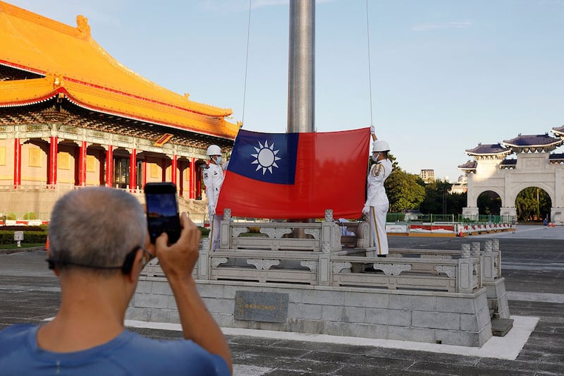 台湾民众8月6日在台北中正纪念堂观看升旗并拍照。（路透社）