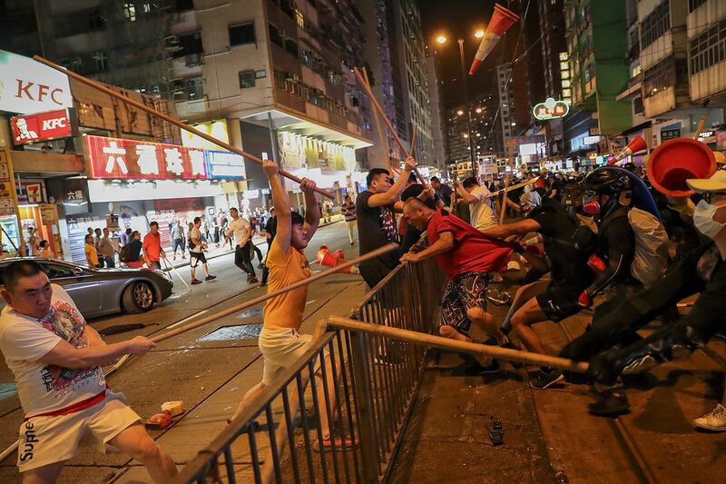 2019年8月5日，一群男子在街上挥舞着木棍袭击香港反送中示威者。（美联社）