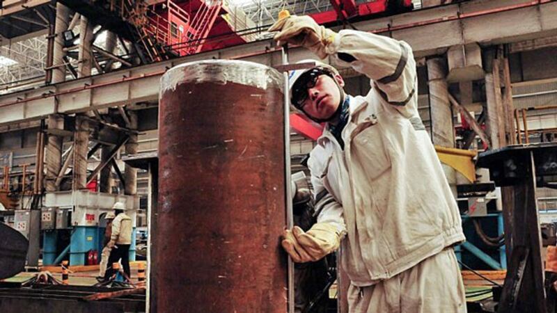 A Chinese worker measures a pipeline at an offshore oil drilling platform in Qingdao, eastern China's Shandong province, April 1, 2016.