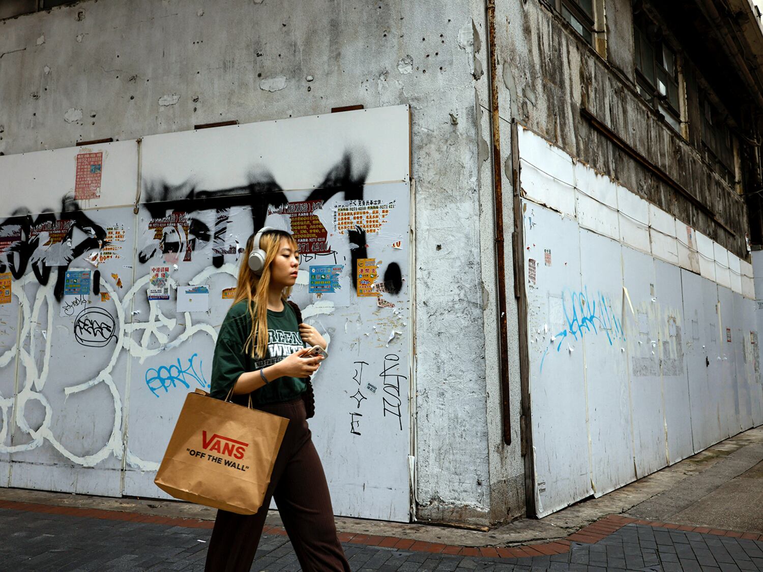 Una mujer pasa junto a una tienda minorista cerrada en Tsim Sha Tsui, Hong Kong, el 29 de abril de 2024.