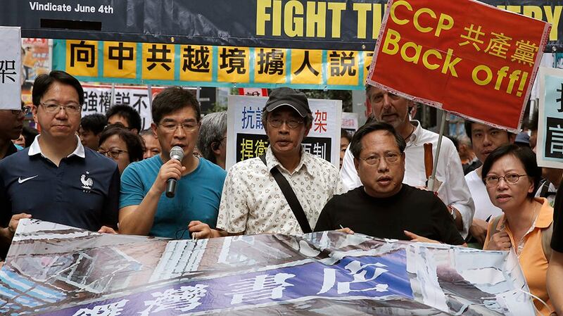 Freed Hong Kong bookseller Lam Wing-kee (C), accompanied by protesters, marches to the Chinese central government's liaison office in Hong Kong, June 18, 2016. Credit: AP Photo