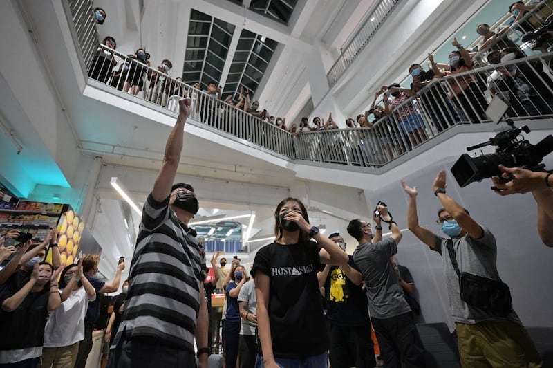 Employees, executive editor in chief Lam Man-Chung (L) and deputy chief editor Chan Pui-Man (C) cheer each other in the Apple Daily newspaper office after completing editing of the final edition in Hong Kong, June 23, 2021. Credit: AFP