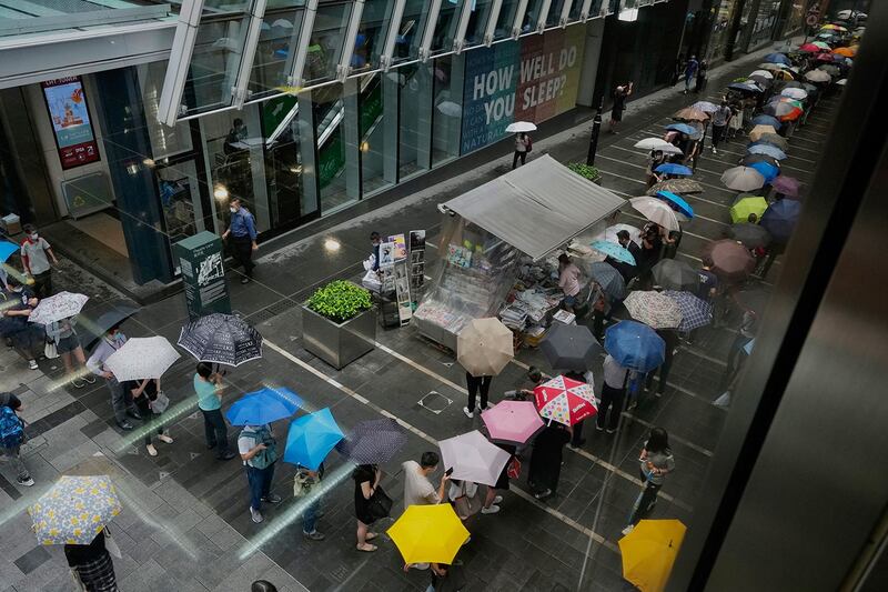 2021 年 6 月 24 日，香港市民在市中心街道的报摊前排队等候最后一期的《苹果日报》。 （美联社）