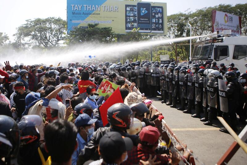 Police fire water cannons at protesters as they demonstrate against the military coup in the capital Naypyidaw, Feb. 9, 2021. AFP