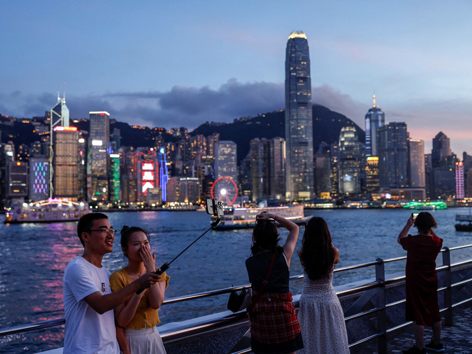 Turistas toman fotografías del distrito financiero de Hong Kong, en Tsim Sha Tsui, el 23 de julio de 2024.