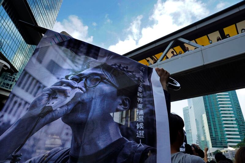 Supporters hold a banner with a picture of Hong Kong activist Edward Leung as they shout slogans outside the High Court in Hong Kong in 2019. Credit: Vincent Yu/AP