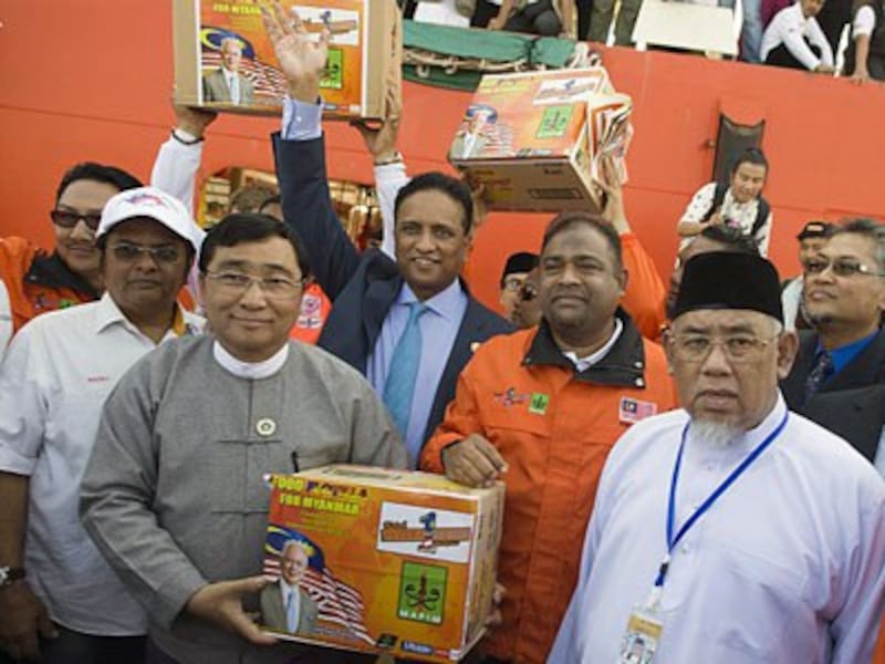 Win Myat Aye (2nd from L) and Malaysian volunteers hold boxes of relief supplies from a Malaysian ship delivering aid for Rohingya Muslims in Thilawa port, Yangon, Feb. 9, 2017.