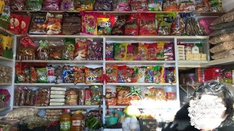 A local snack bar in Chongjin, North Hamgyong Province, North Korea sells snacks produced by state-run factories in a file photo. (Face digitally obscured to conceal identity.) credit: 