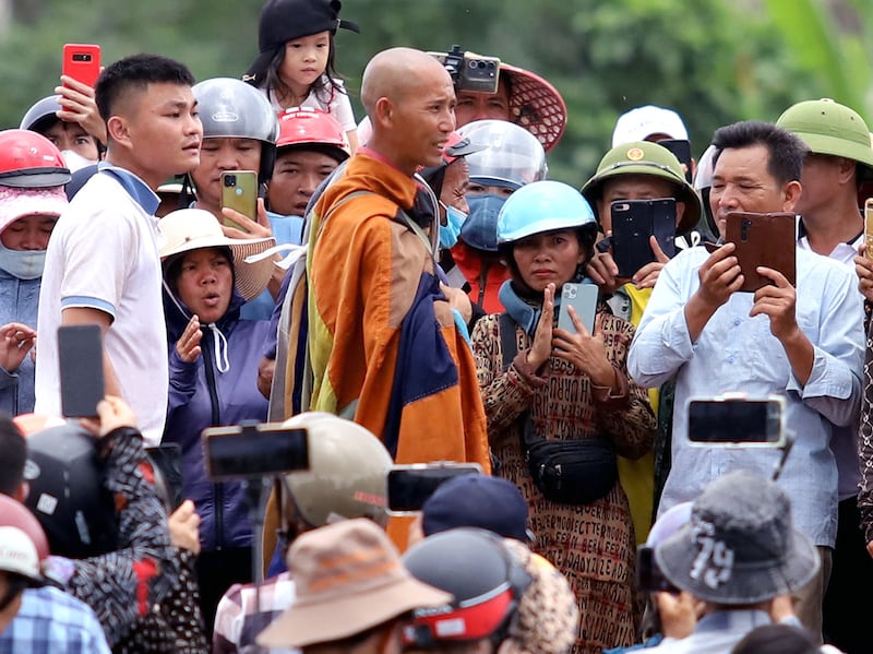 Buddhist monkl Thich Minh Tue, center, stands with local residents in Vietnam's Ha Tinh province on May 17, 2024. (AFP Photo)