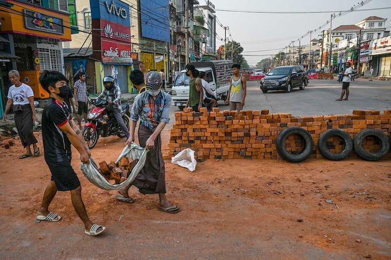 Seeking to create shelter from live rounds fired by police and the military, protesters in Yangon built a barricade from bricks. (AFP)