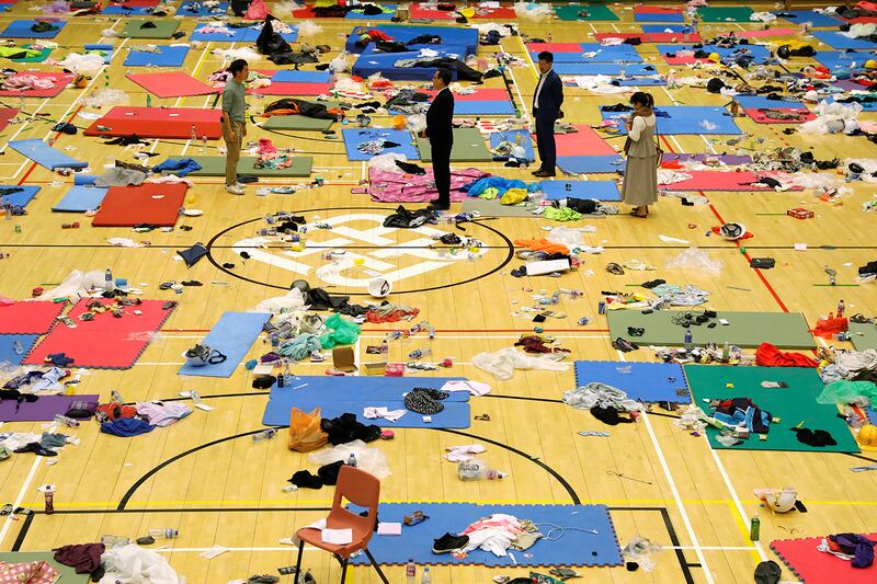 Pro-democracy lawmakers stand amid items left behind by protestors in Hong Kong Polytechnic University in Hong Kong, Nov. 26, 2019.