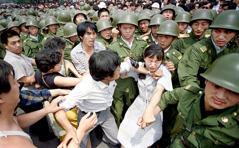 A young woman is caught between civilians and Chinese soldiers, who were trying to remove her from an assembly near the Great Hall of the People in Beijing, June 3, 1989.(Jeff WidenerAP)