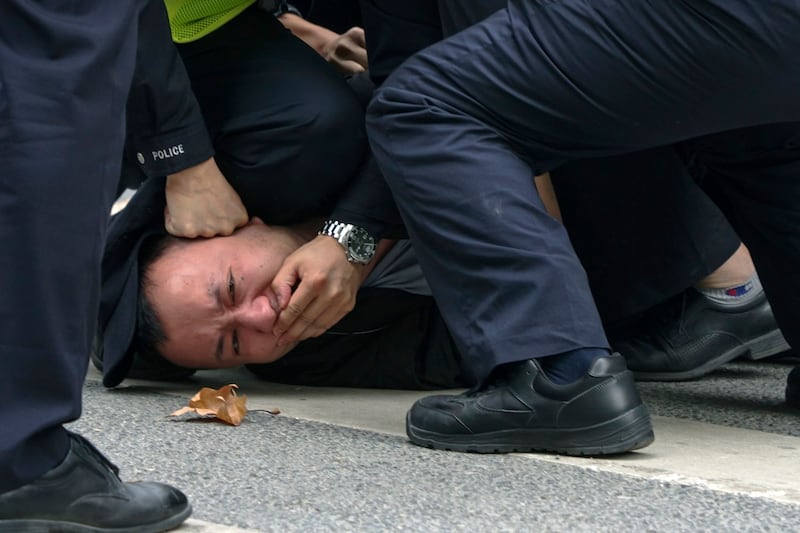 Chinese police pin down and detain a protester during a protest against COVID-19 measures on a street in Shanghai, China on Nov. 27, 2022. Credit: AP