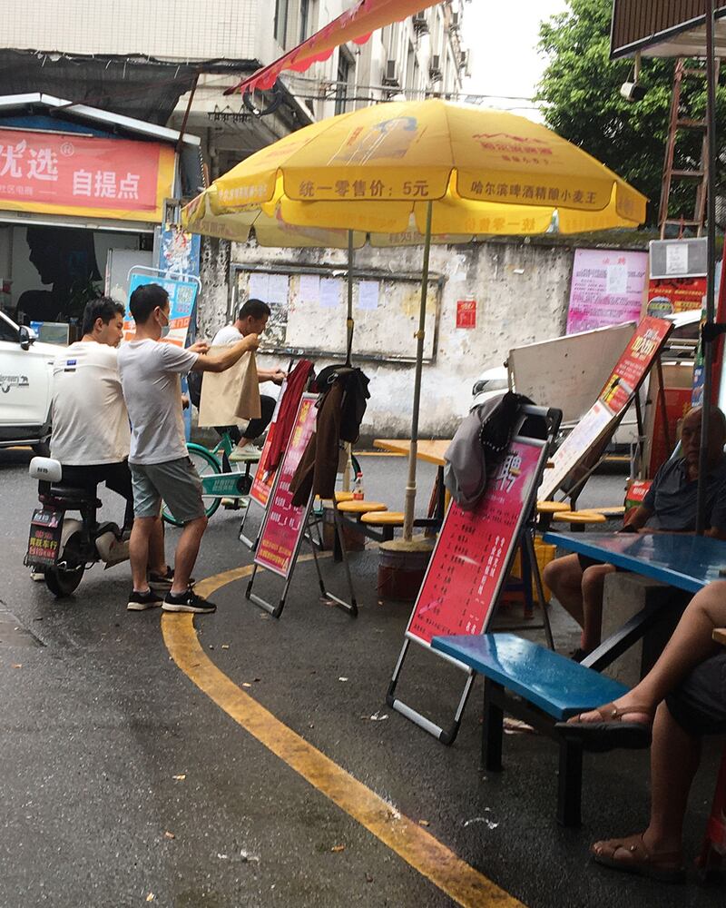 Red advertising boards seeking garment workers in Guangzhou's Nancun garment district feature a sample lying on top to indicate the level of skill being sought are seen in this undated photo.