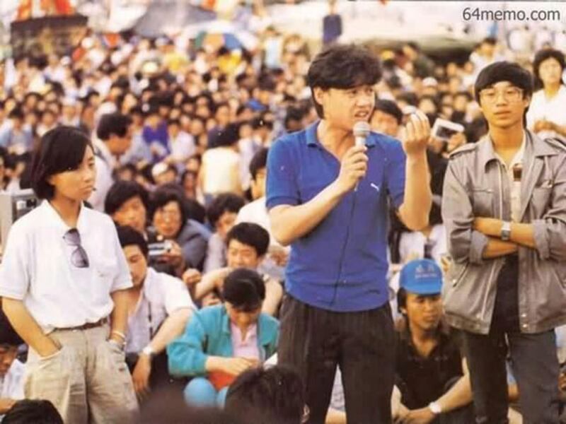 1989年5月27日，吾尔开希（中）在天安门广场学生大会上讲话。旁边是柴玲（左）和王丹（右）。（六四档案）