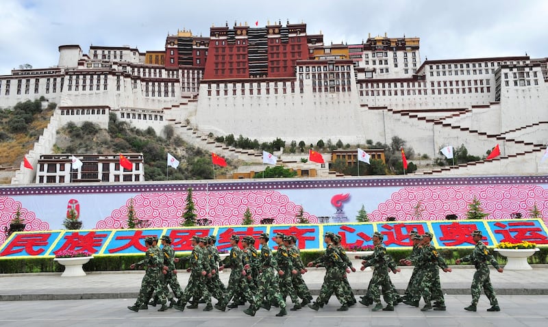 Chinese paramilitary policemen patrol past the Potala Palace in Lhasa months after protests sparked widespread unrest in the region, June 21, 2008. Credit: AFP