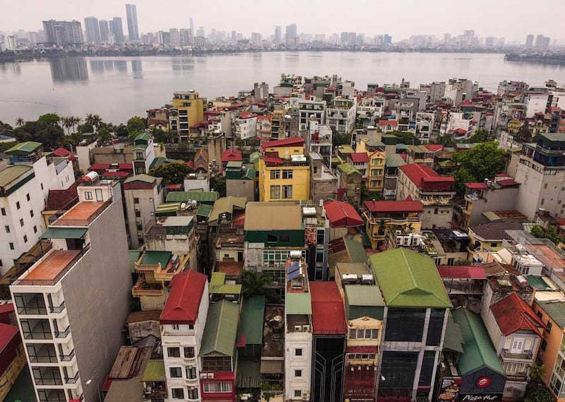 The two white buildings in the bottom center of the photo show the difference that just a few feet can make. The home on the left accommodates a balcony on each floor while the noticeably narrower one lacks the feature. (AFP)