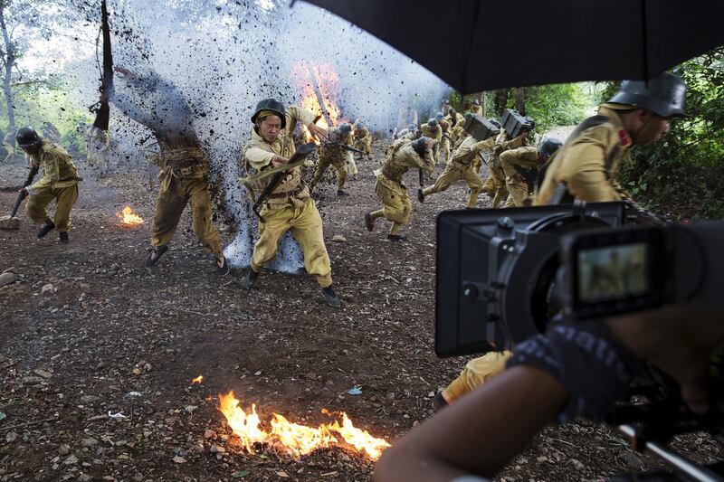 The camera rolls as actors dressed as historical Chinese soldiers act as though they have been hit by artillery fire, during filming of 'The Last Prince' television series at Hengdian World Studios in Hengdian, July 24, 2015.