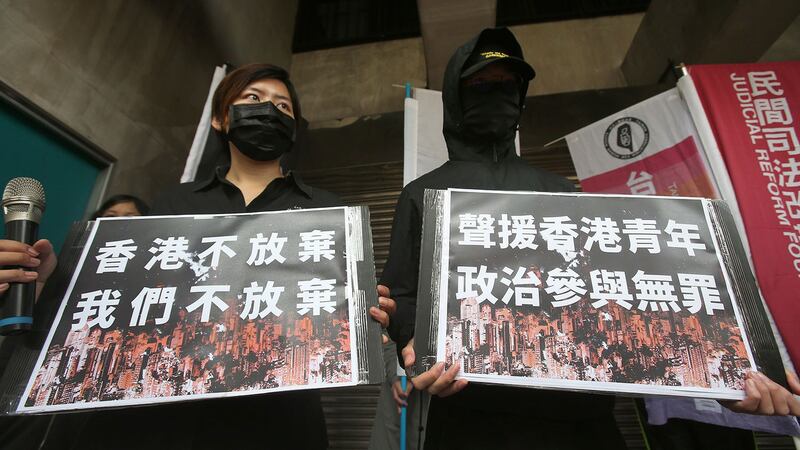 资料图片：2021 年 3 月 2 日，台湾抗议者高举标语声援香港民主活动人士。 （美联社）